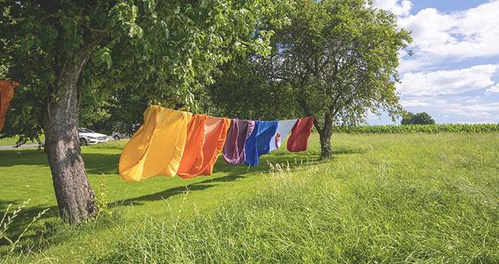 colorful clothes drying on clothesline between two trees